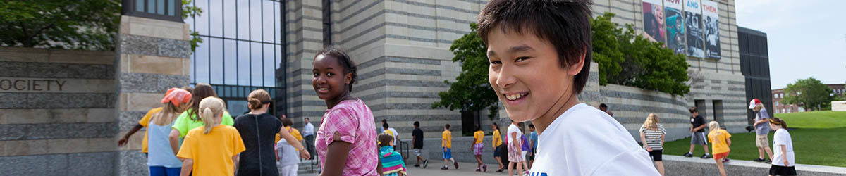Field trips students entering the history center building with smiling face.