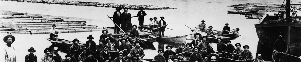 Lumberjacks on boats looking at the camera direction, black and white photo.