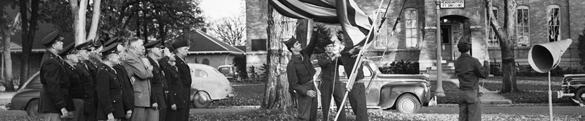 soldiers raising flag up a pole