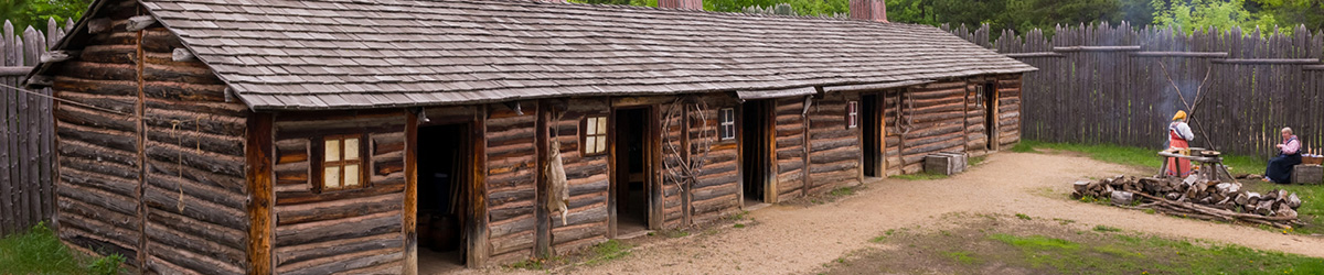 A front view of the Snake River Fur Post with two people dressed in costume working up front.