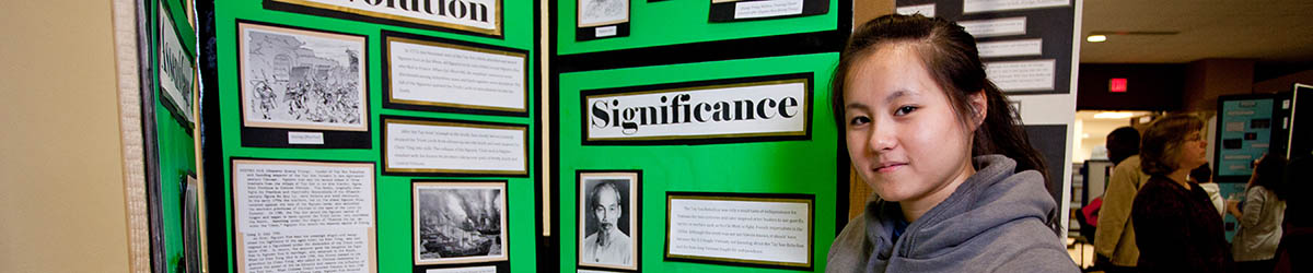 Student standing in front of a poster board.