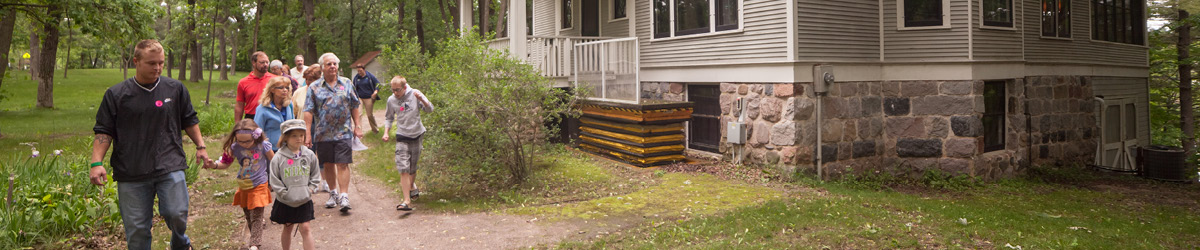 People walking on a path in front of the Lindbergh house.