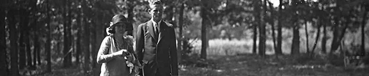 Charles Lindbergh walks next to Anne near some woods.