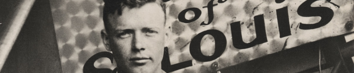 Lindbergh standing in front of a sign, which says Spirit of St. Louis.