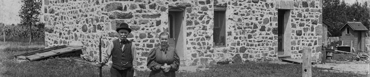 A couple standing in front of the Lower Sioux Agency warehouse in 1897.