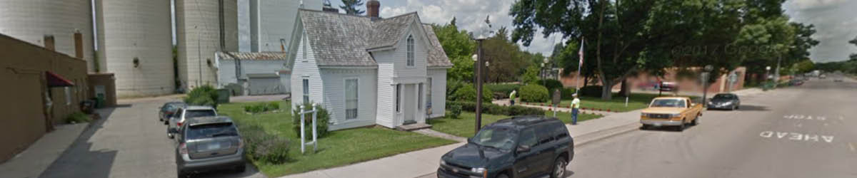 Street view of W. W. Mayo House with cars parked in front.