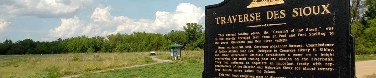 A sign titled "Traverse des Sioux" beside a wavy path.