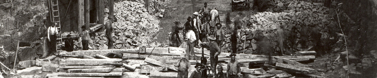 A black and white photo of workers cutting up lumber.