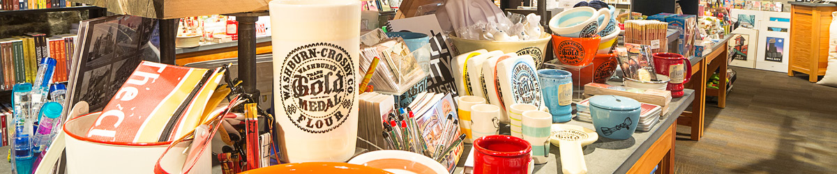 A selection of items sold in the Mill City Museum gift shop: books, mugs, ceramics, and pens.
