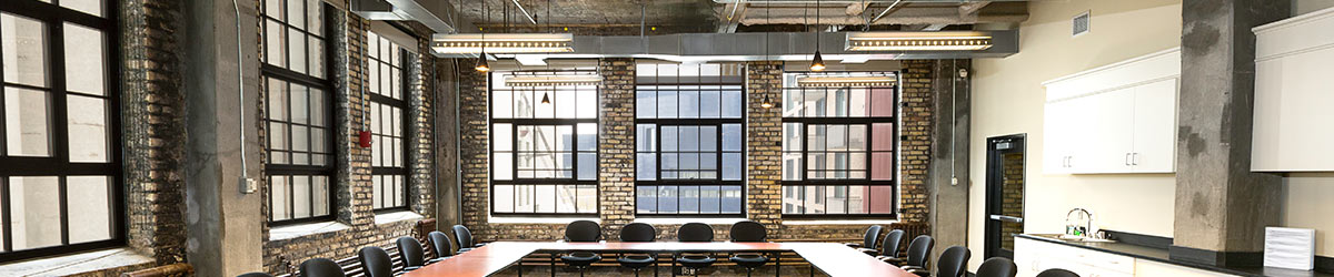 Conference room with exposed stone walls and u shaped table.