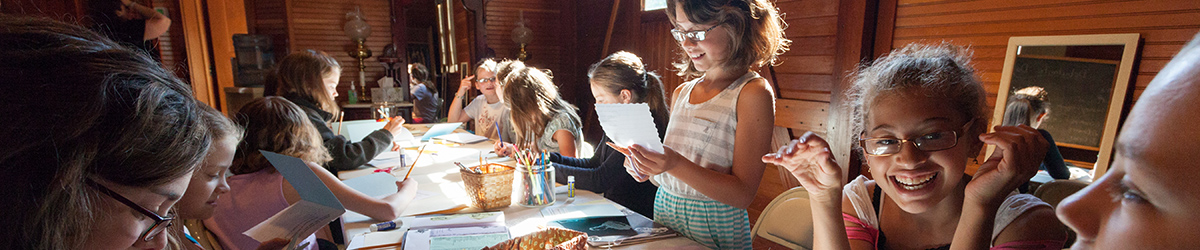 Girls sitting around a table working on a craft