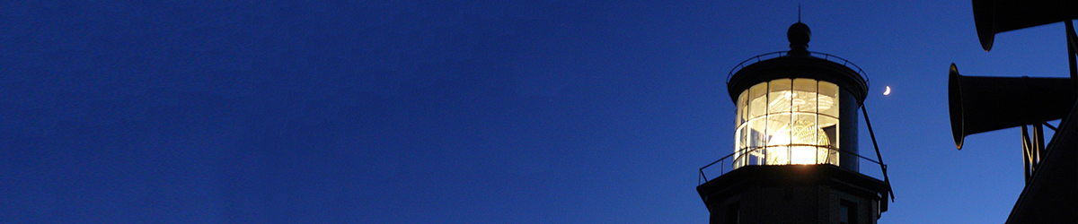 Closeup of the lit beacon with a crescent moon in the background
