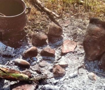 Historic cooking implements around coals