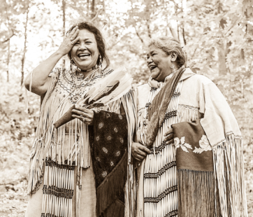 Sepia-toned image of two Indigenous women walking in woods