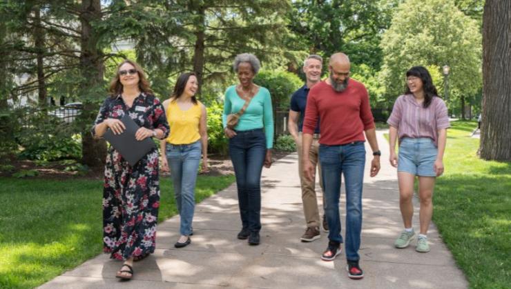 A guide leads a group down the sidewalk