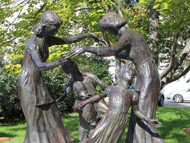Statue titled "The Mothers" where two mothers play with their children.